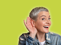 Eine Frau hält ihre Hand ans Ohr, um zu hören